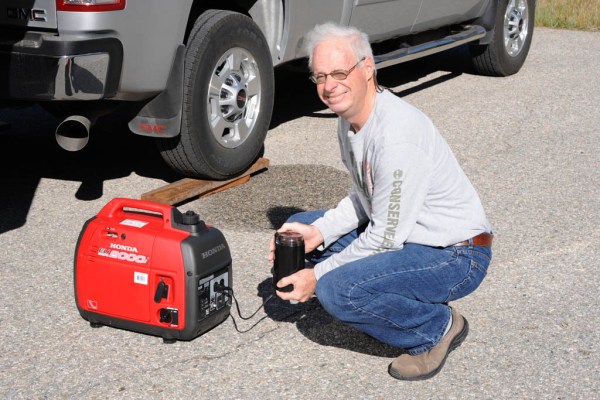 Dad the barista grinding the morning's coffee beans with the help of the Honda generator.