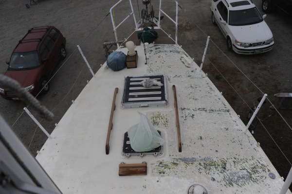 A colorful 30-year history of deck paint unfolds as grinding begins on the starboard side.