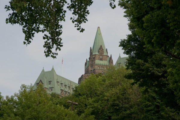 Parliament Buildings peeking through the trees of the Colline du Parlement, Ottawa.
