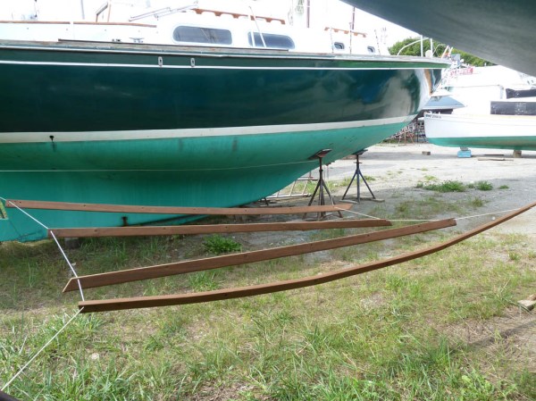 The toe-rails hanging between neighboring boats after the third and final coat of varnish (Sikkens Cetol).