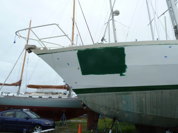 Test patch of "Forest Green" to make sure it matches Northern Cross's "natural color." Note the bits of blue tape which mark areas needing grinding and epoxy.