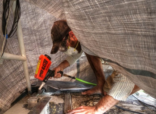 Sandblasting around the backstay chainplates and stern cleats after hours of removing chipped paint with a cold chisel and hammer. - HDR