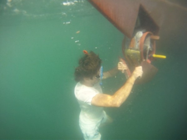 Nicolas and I preparing to use an underwater drill to re-secure the bow thruster fairing to its housing.