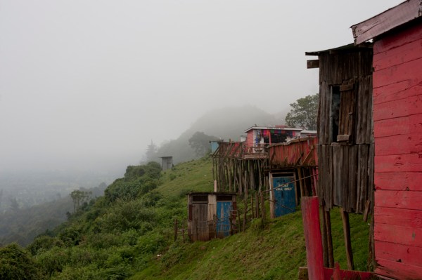 Houses and tourist shops line the roadside viewpoint.