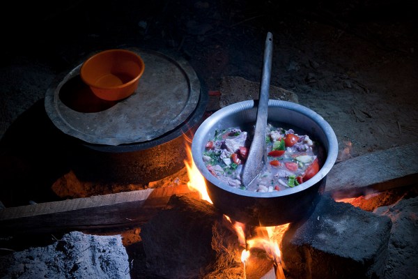 A delicious goat stew in the works over the campfire.