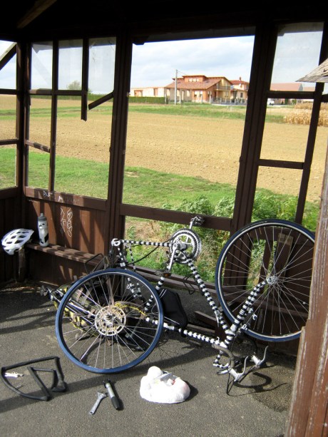 Fixing the first flat tire of the trip in an abandoned Hungarian bus stop.
