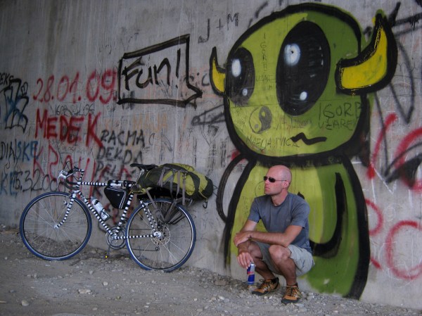 Re-energizing with a Red Bull, gift from Cigdem for the road, along the Drava River.